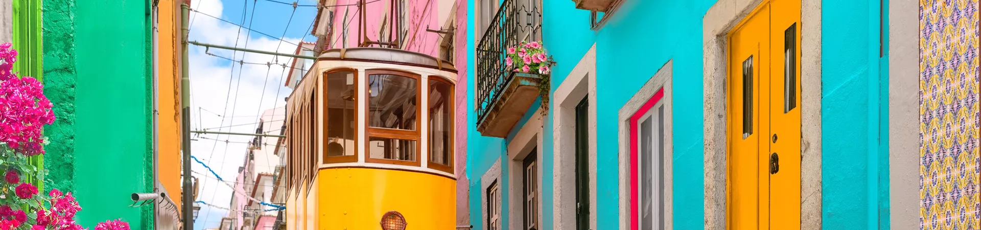 Yellow tram passing colourful houses in Lisbon, Portugal