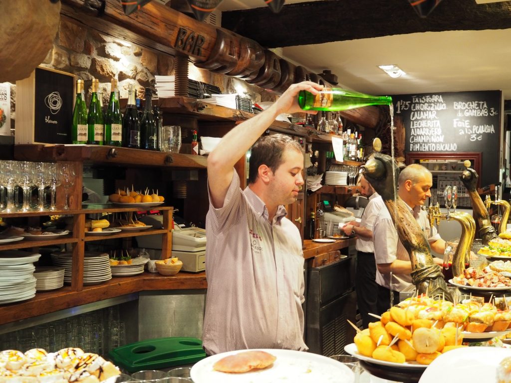 A man pouring a bottle of wine during a holiday in northern Spain.