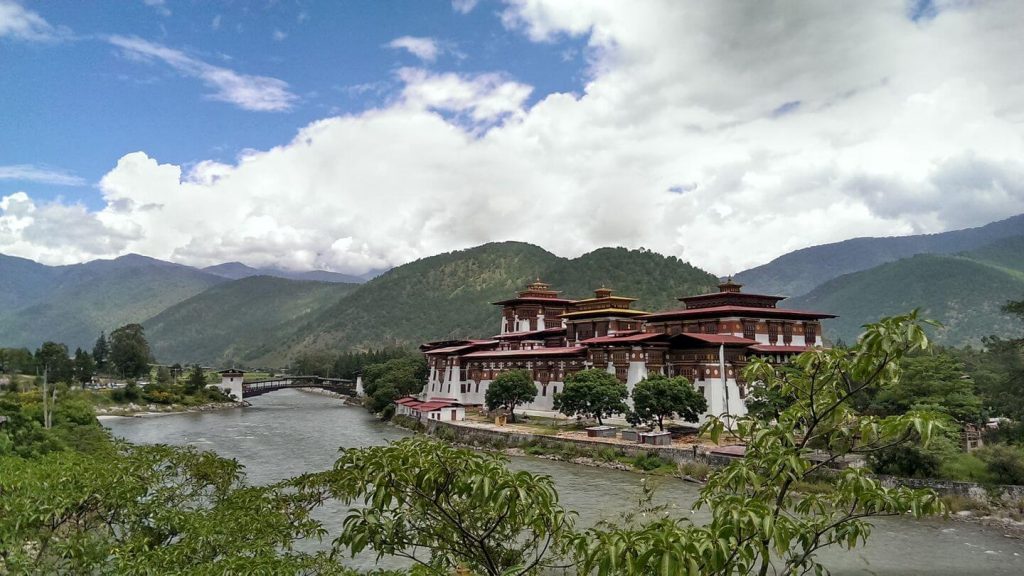 temple beside river and mountains visit bhutan