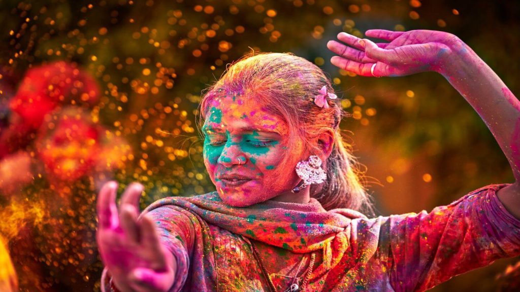 woman dancing colourful powder holi festival india