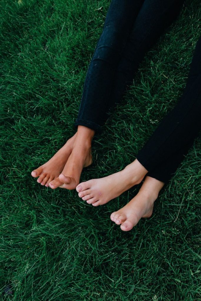 two people with bare feet in green grass