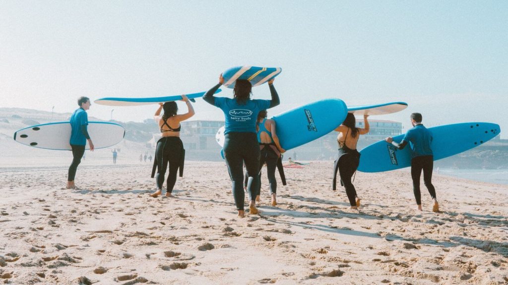 group of people learning to surf on the beach