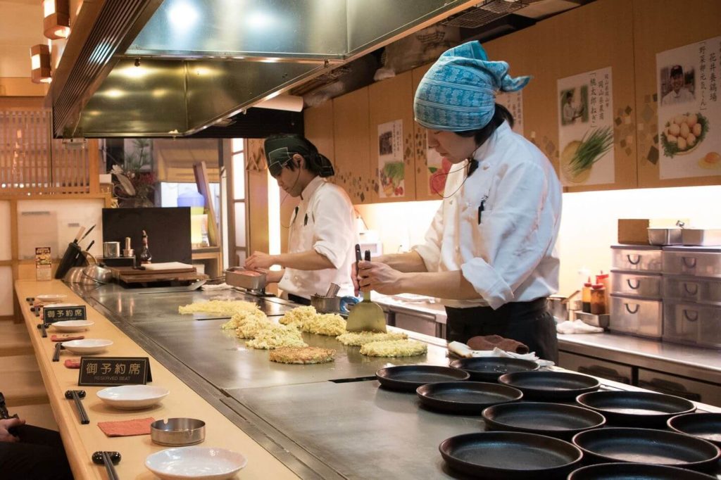 chefs making Hiroshima-style okonomiyaki Japan travel guide