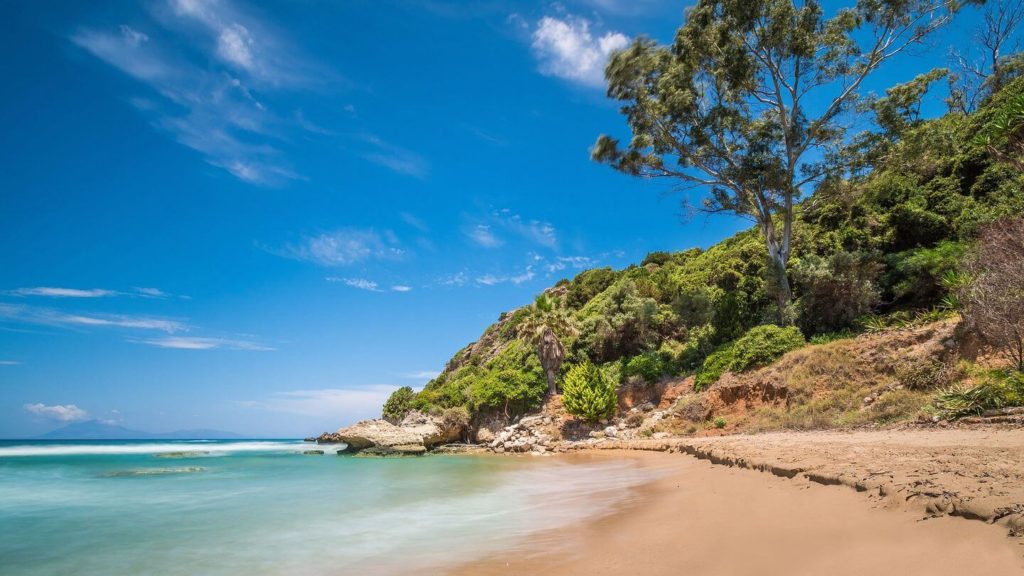 sandy beach lush trees Peloponnesian peninsula Greece