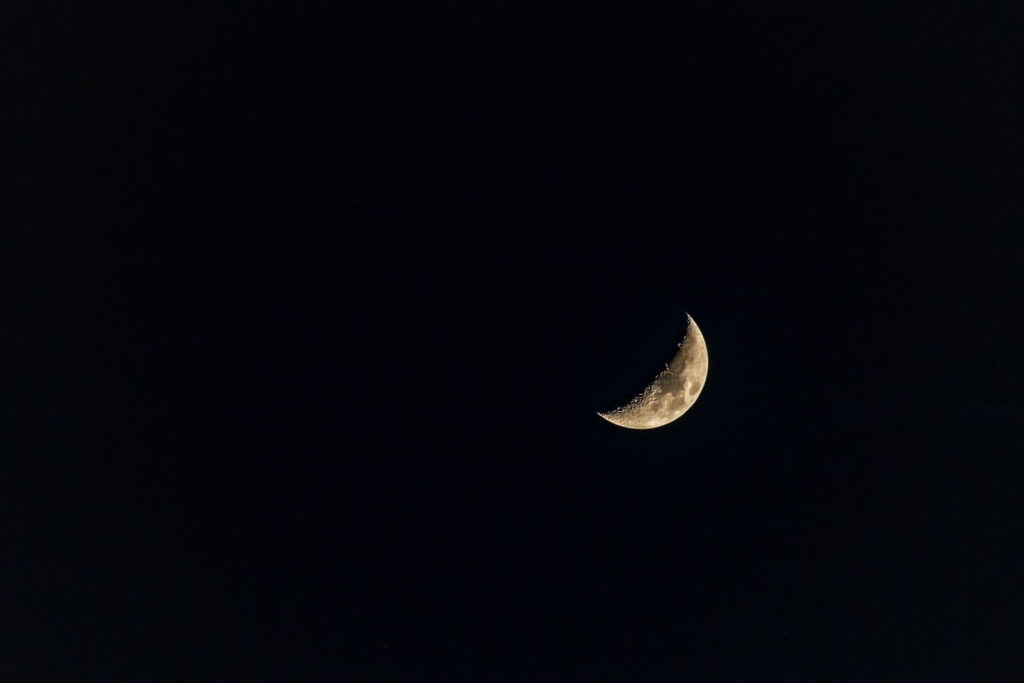 crescent moon in the dark night sky