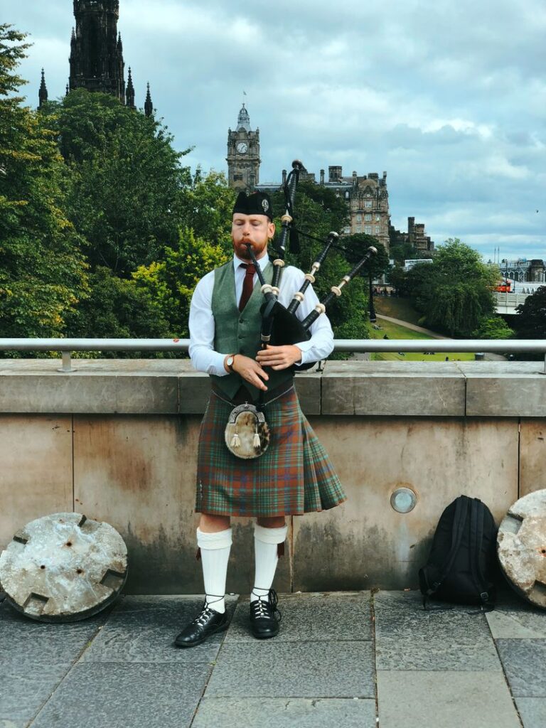 Scottish man wearing kilt and playing bagpipes