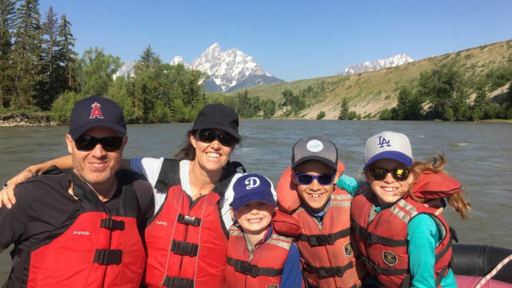 family posing for photo on a river 