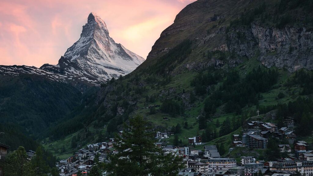 The Matterhorn in Switzerland, silhouetted against a pink sunset sky