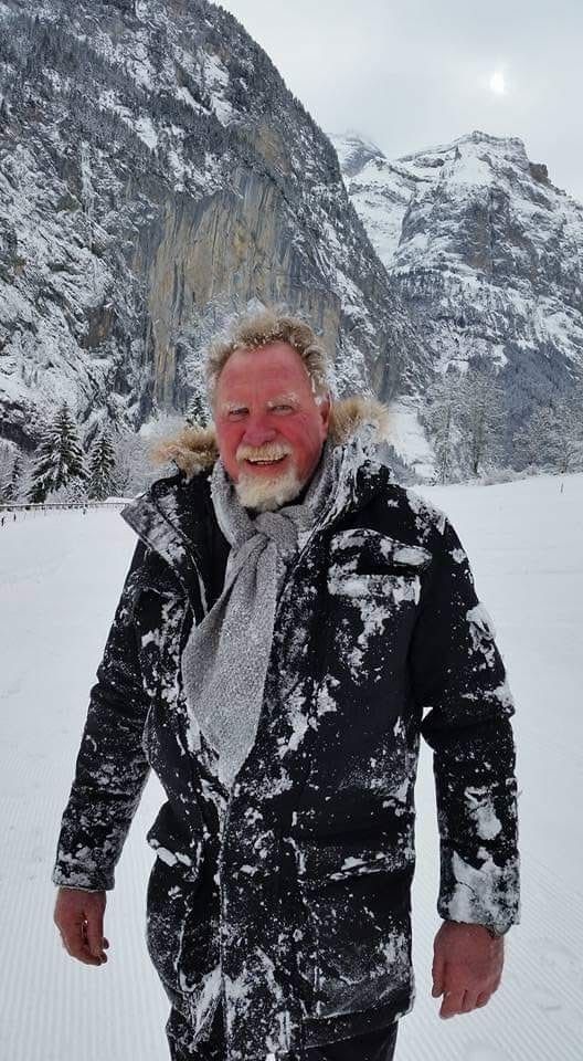 Man in black coat covered in snow