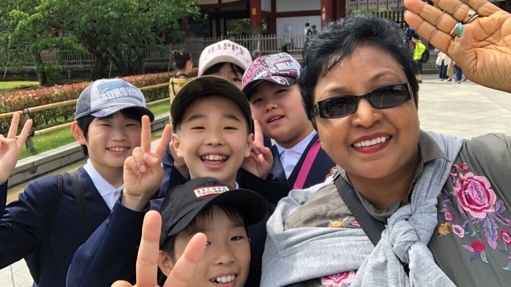 Past Trafalgar guest Chetralekha S. takes a selfie with local children in Japan 