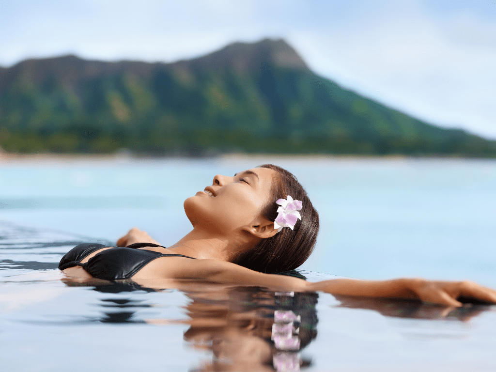 Woman with flower in her hair lying back in the sea relaxing and floating