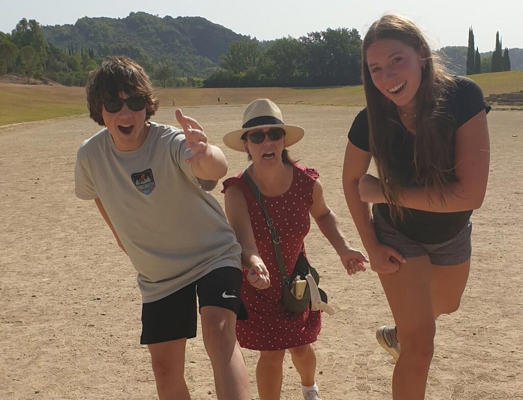 Julie, striking a running pose with her two kids 